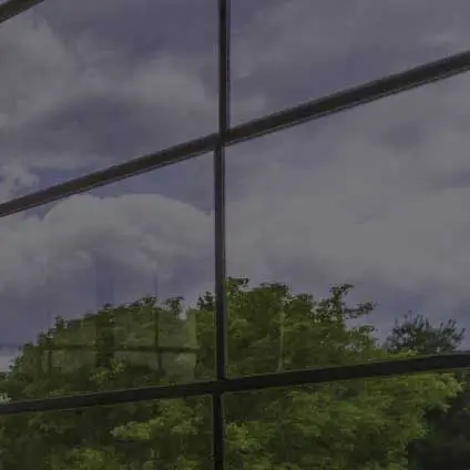 A close-up view of Dark tinted WeatherMaster vinyl windows in a Model 200 Sunroom, providing shade and visibility.